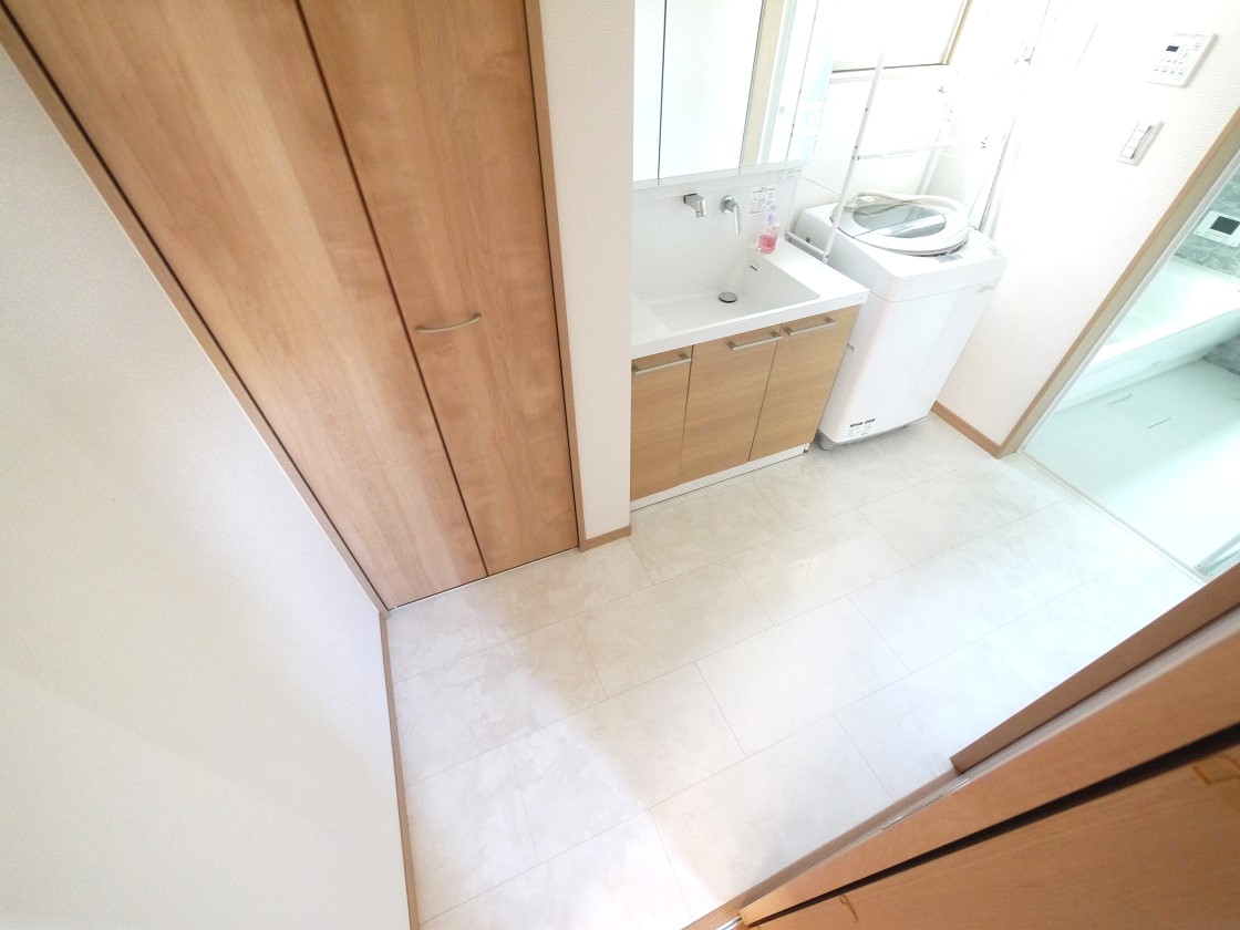 たっぷりの収納を設けた洗面室 シャワー付洗面台で快適な暮らし